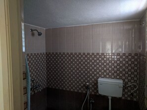 Bathroom features a checkered tile floor and walls, a toilet, and a light fixture.