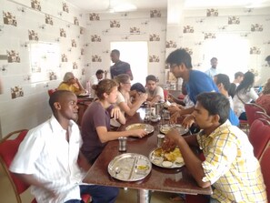 Guests can enjoy meals together at a large, round table in this dining area.