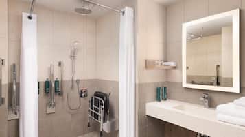 A modern bathroom with a shower, a sink, a mirror, and a towel rack.