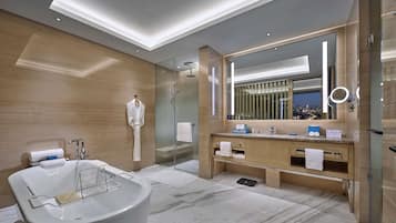 A modern bathroom with a freestanding bathtub, a glass-enclosed shower, and a vanity with a large mirror.