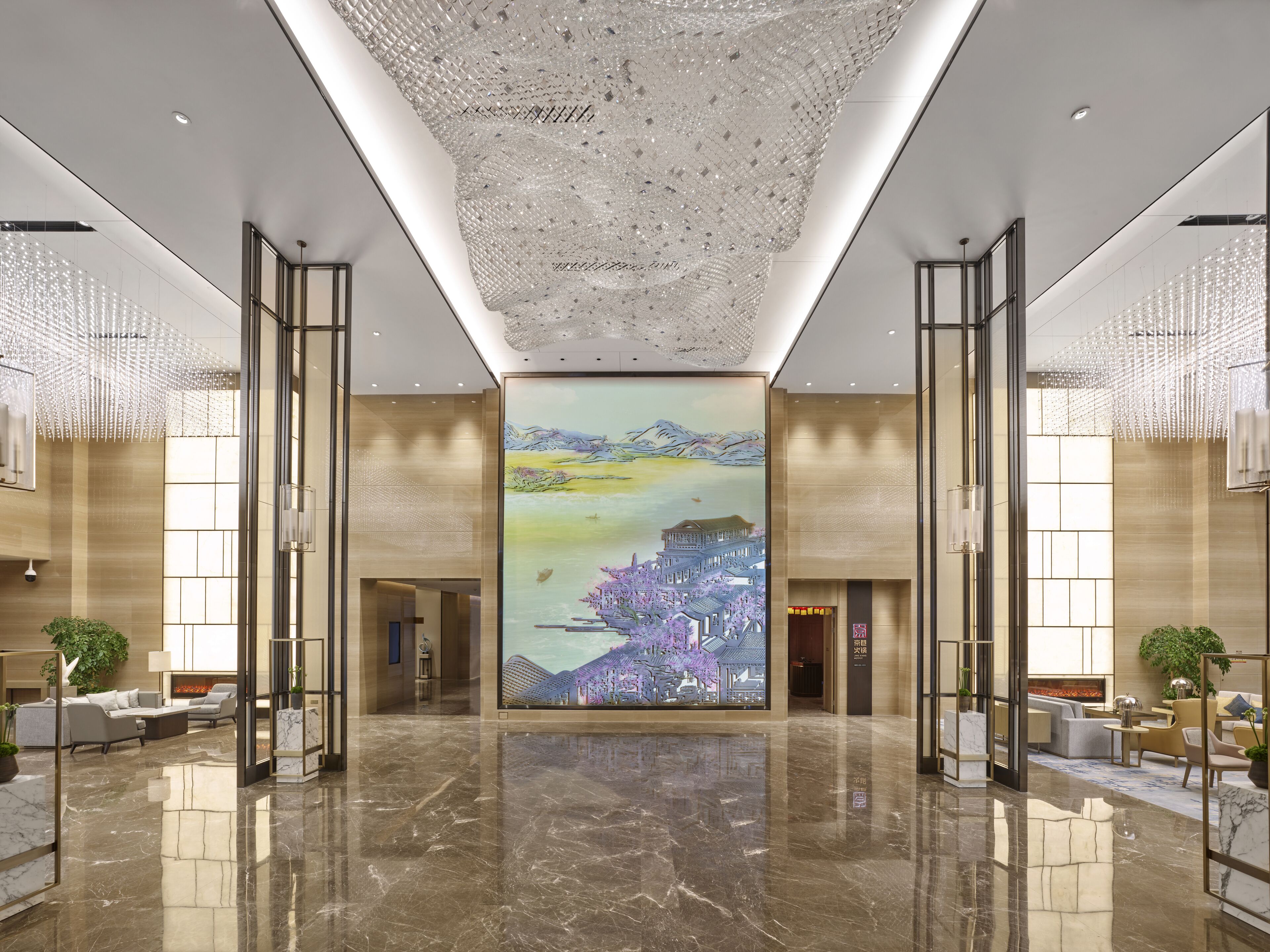 A spacious lobby with a large digital art display, marble flooring, and modern lighting fixtures.