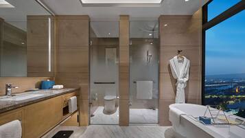 A modern bathroom with a large mirror, a bathtub, and a shower.