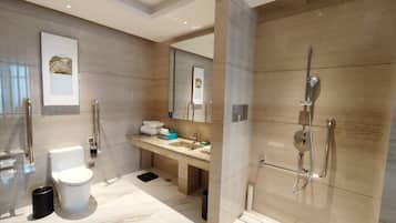 A modern bathroom with a toilet, sink, and shower.