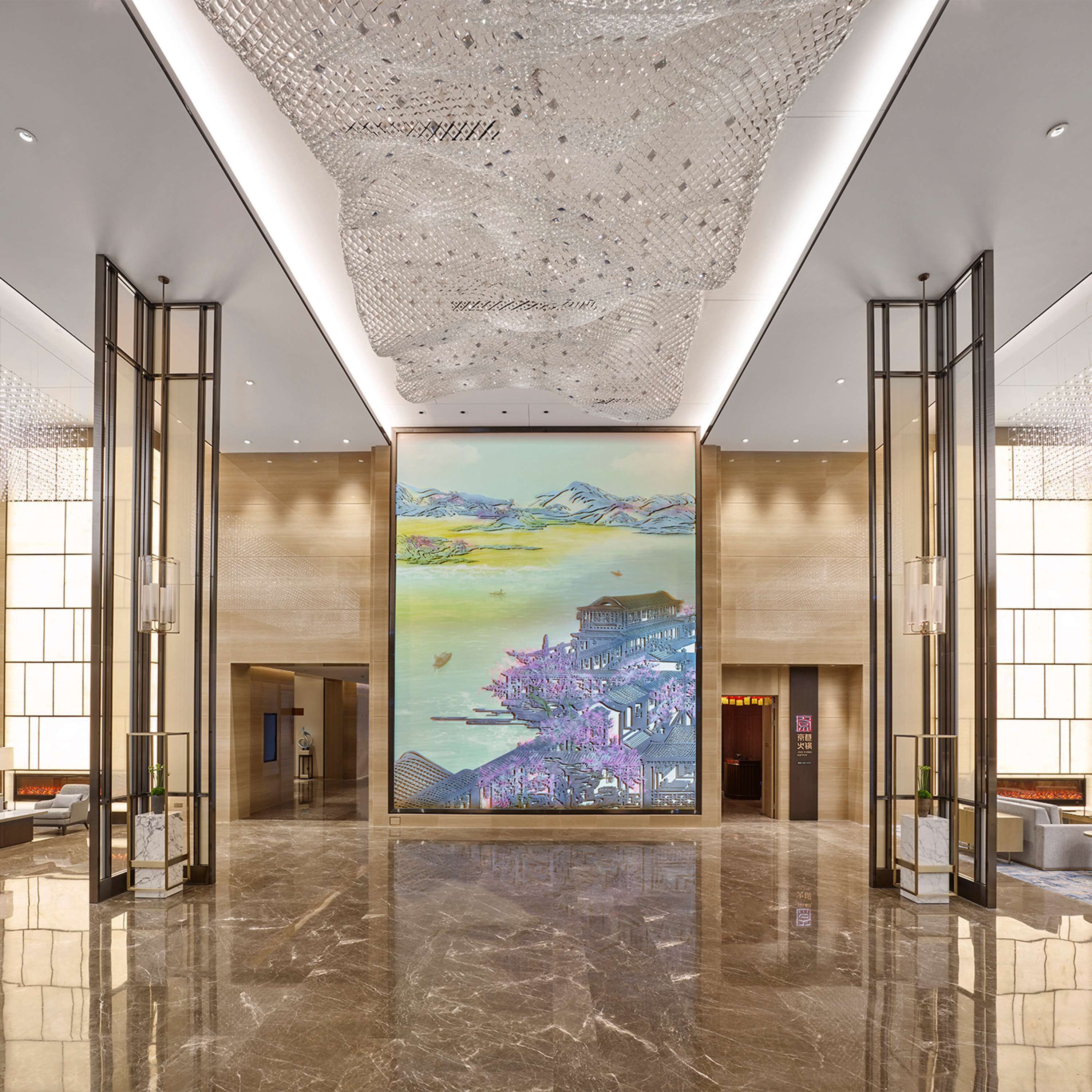 Eine geräumige Lobby mit einer großen Wandmalerei, poliertem Marmorboden und modernen Leuchten.