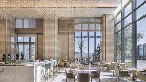 A modern cafe with a marble counter, large windows, and a patterned floor. - Hilton Beijing Tongzhou (Tongzhou)