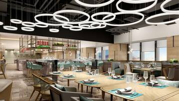 Un restaurant moderne doté de nombreuses tables, de luminaires circulaires suspendus et offrant une vue sur le ciel grâce à de grandes fenêtres.