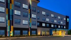 A modern hotel with a multi-story structure, large windows, and a prominent vertical light strip. - Tru by Hilton Spartanburg (Spartanburg)