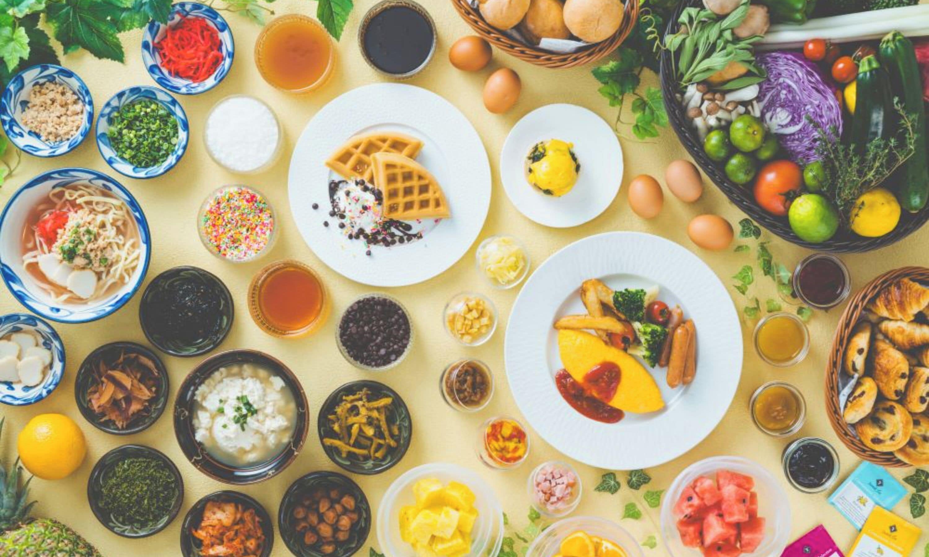 A table with various dishes, including waffles, fruit, and condiments.