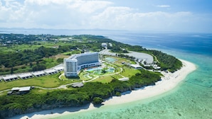 A resort with a large building, a pool area, and a beach. - Hilton Okinawa Sesoko Resort (Motobu)
