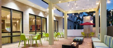 An outdoor patio area with seating, tables, and string lights.