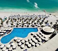 Magánstrand, fehér homok, napozóágyak és napernyők