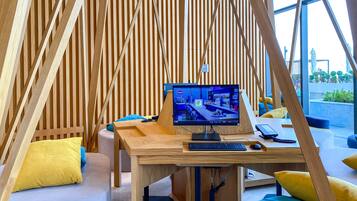 A modern room with a wooden slatted wall, a desk with a computer, and a view of the outside.