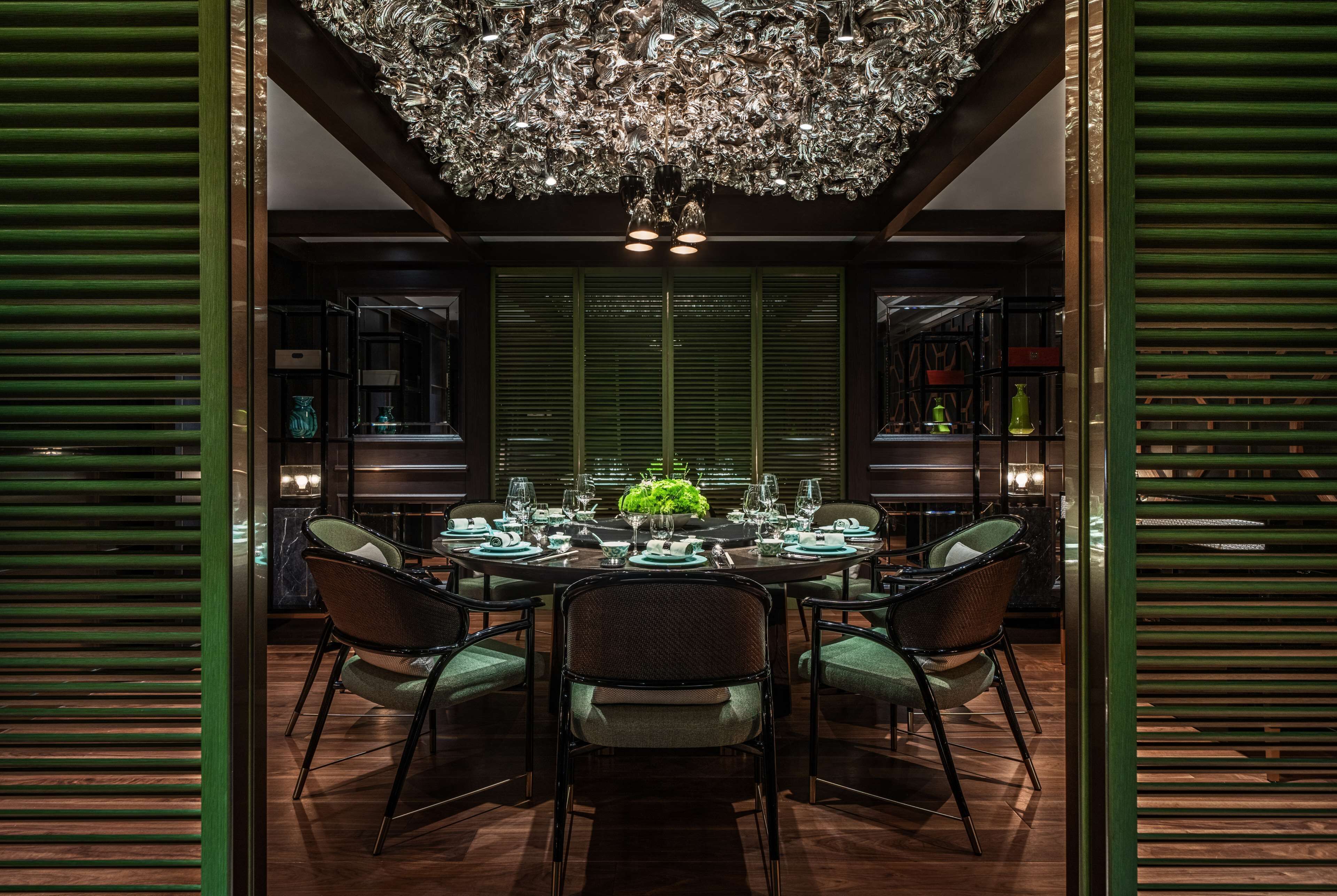 A formal dining room with a round table set for six, surrounded by six chairs.