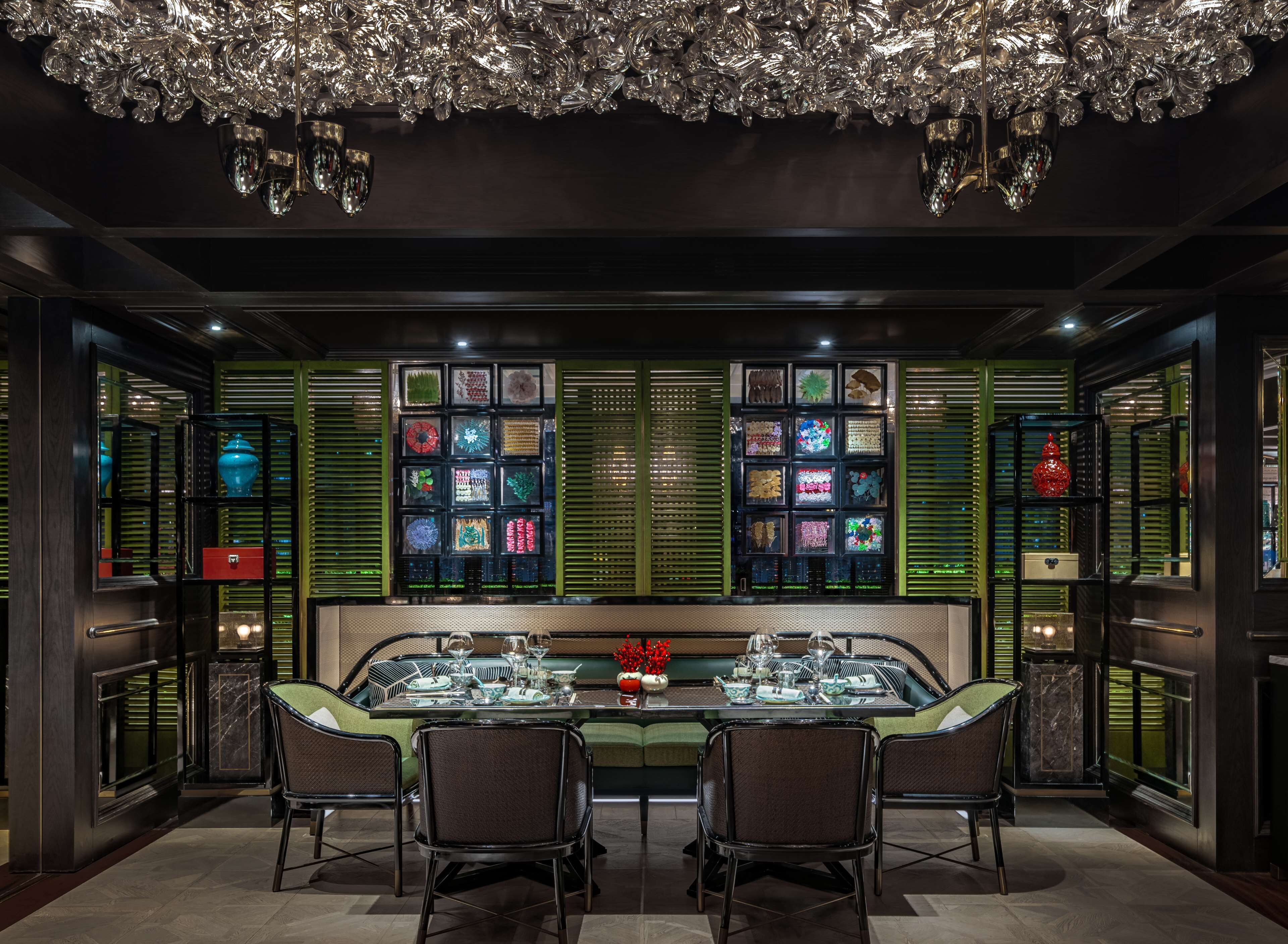 Un comedor con una mesa de vidrio, sillas y una lámpara decorativa.