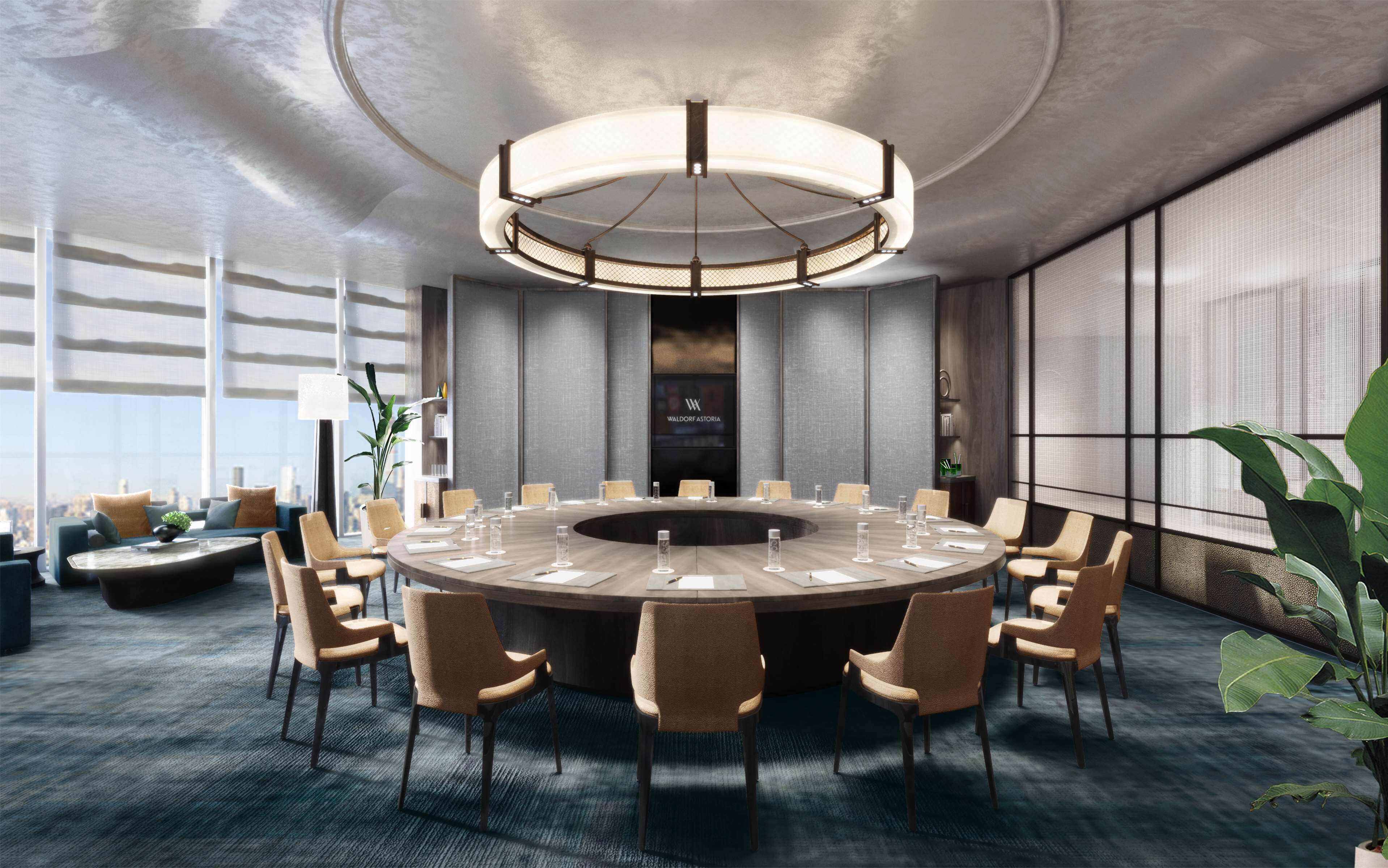 A modern conference room with a round table, chairs, and a large chandelier.
