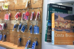 A wall with keys hanging on a rack, each labeled with room and bed numbers. - Mana Mana Youth Hostel (Tossa de Mar)