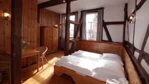 A wooden room with a bed, a wooden desk, and a chair.