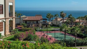 A resort with a tennis court, palm trees, and ocean views. - Pueblo Bonito Sunset Resort, Cabo San Lucas, Mexico (Cabo San Lucas)