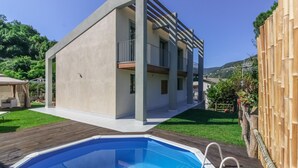 A modern two-story house with a swimming pool, a covered patio, and a wooden deck. - Detached villa with outdoor hot tub, swimming pool and lawn  (La Spezia)