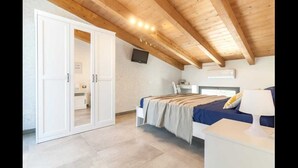 A bedroom with a bed, bedside table, and a wardrobe. - Detached villa with outdoor hot tub, swimming pool and lawn  (La Spezia)