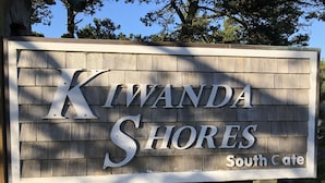 Een houten bord met de tekst 'Kiwanda Shores South Gate'.