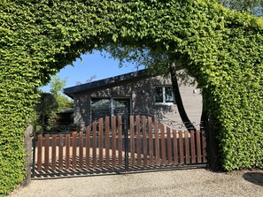 Et hus med en lukket indgang, omgivet af frodig vegetation.