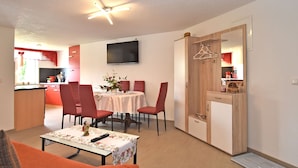 A compact living space with a dining area, a kitchen, and a seating area with a table and chairs. - Komfort und Naturflucht, Lichtenhain (Sebnitz)