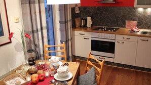 Une cuisine équipée d’une table à manger pour deux personnes, d’une cuisinière et d’un évier.
