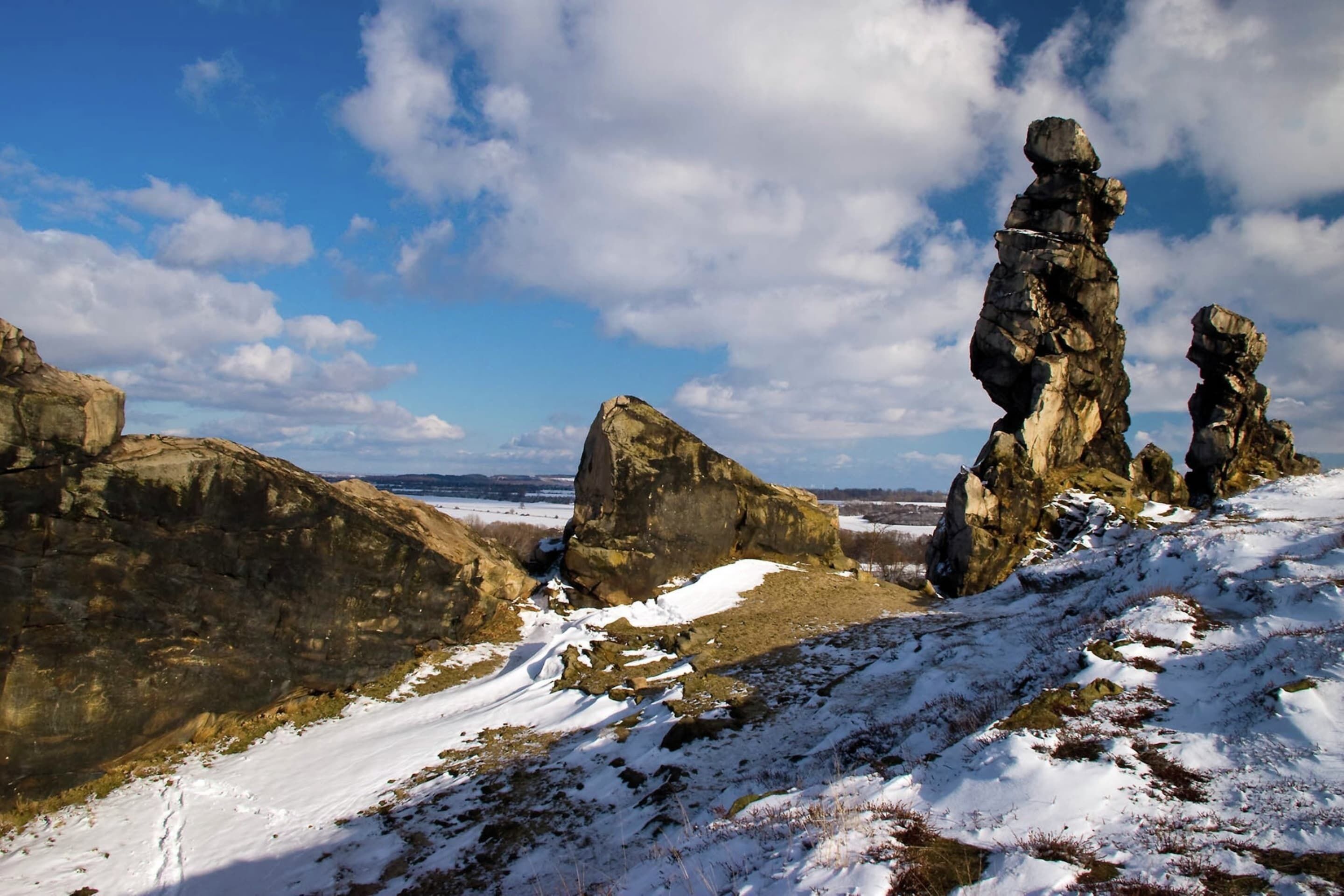 A snowy landscape with large rock formations and a clear sky.