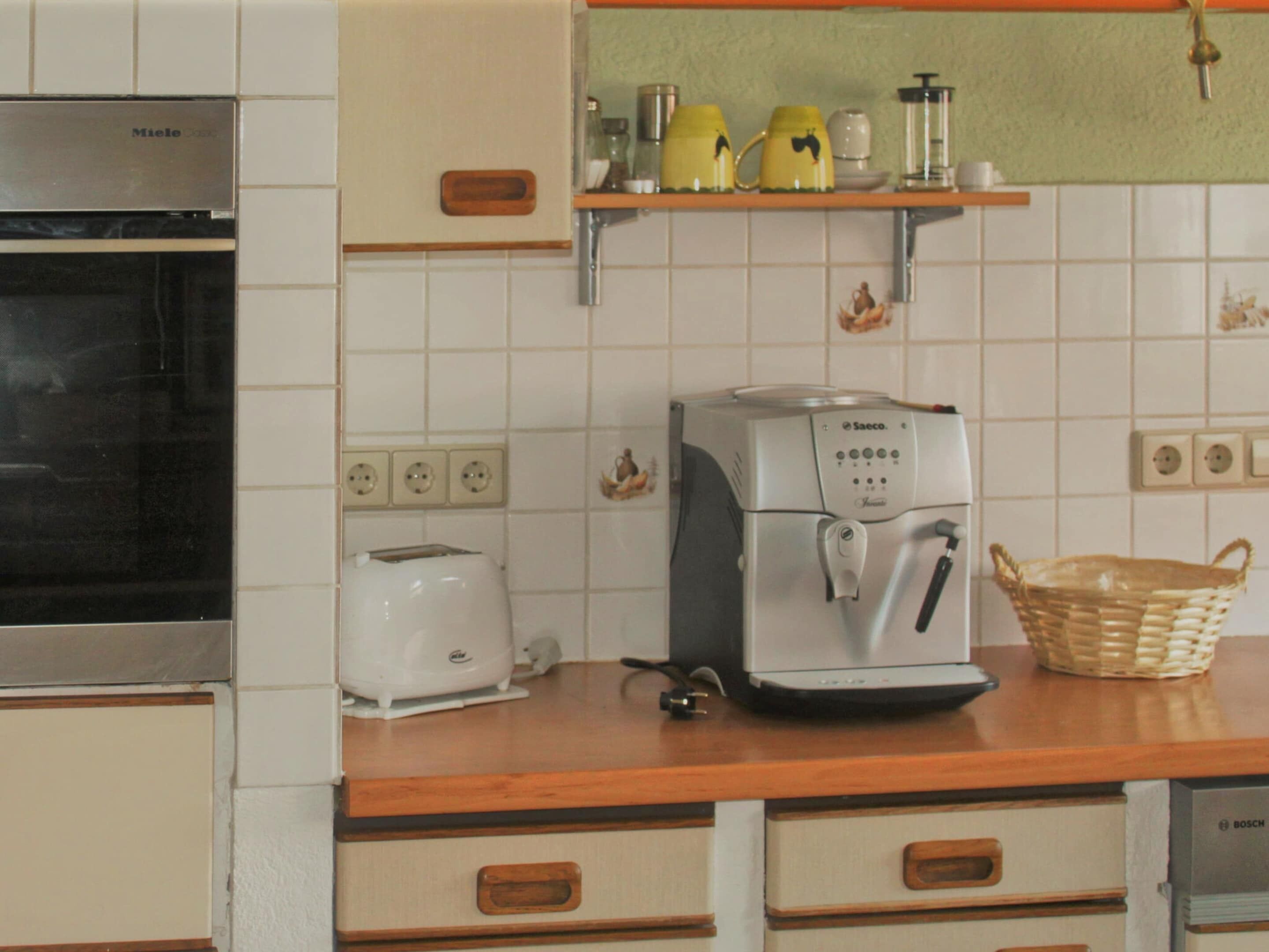 A kitchen with a coffee maker, toaster, and a basket on the counter.