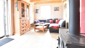 Un salon chaleureux avec un canapé, des meubles en bois, une cheminée et un téléviseur.