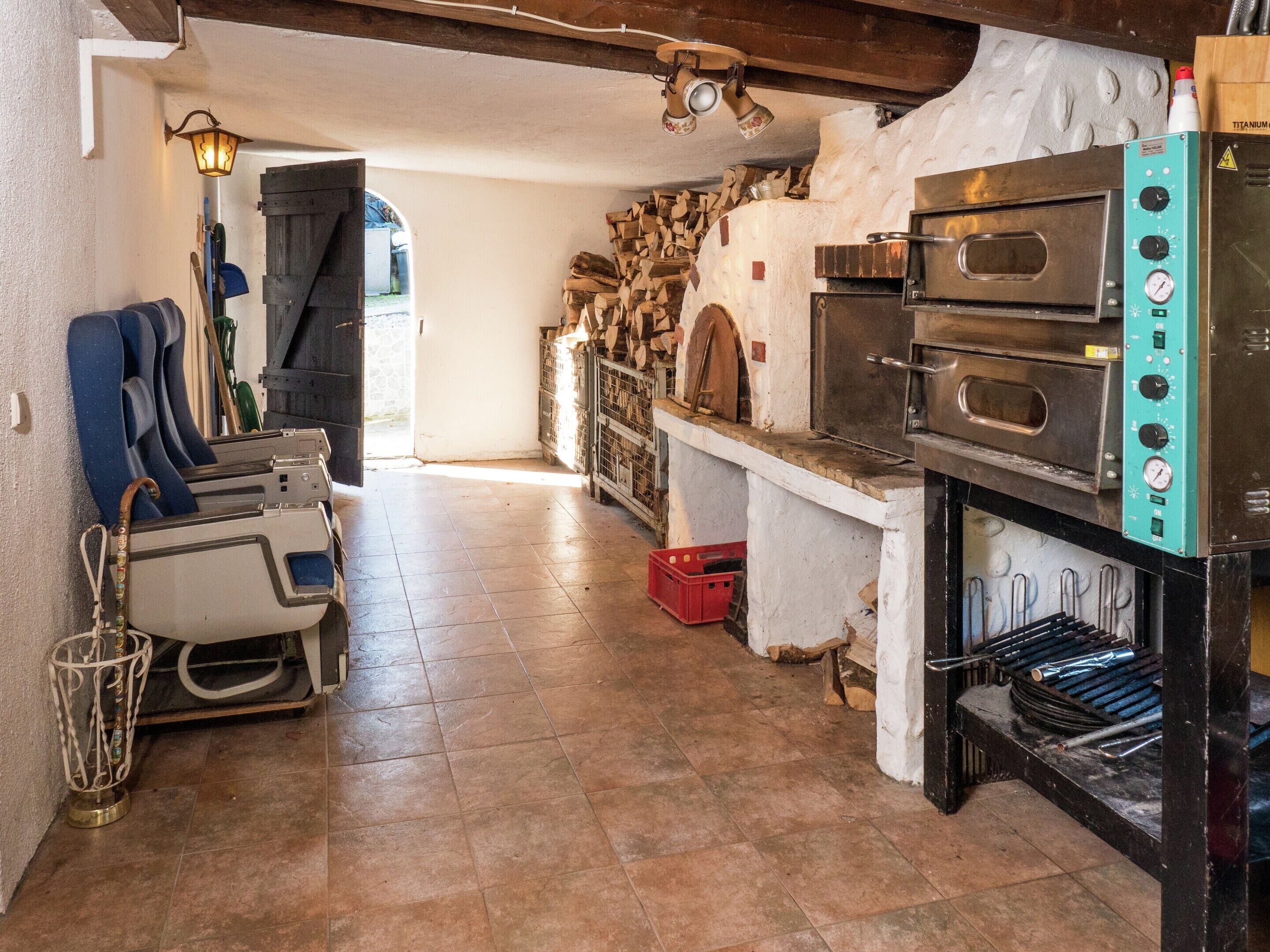 Une cuisine équipée de deux fours, d’une cuisinière et d’un coin repas avec des chaises.