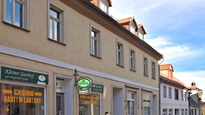 A row of buildings with storefronts, including a visible sign for 'Kleiner Gasthof' and 'Casino Dart W-Lan Sky'.