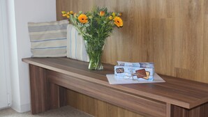 Una panca di legno con un vaso di fiori e una scatola di barrette di cioccolato.