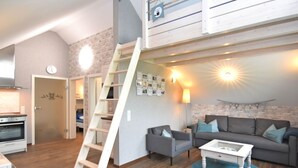 A modern apartment with a loft-style living area, a kitchen, and a staircase. - Ferienhaus in Obernburg am Edersee (Voehl)
