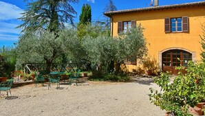 A yellow building with a garden, outdoor seating, and a gravel courtyard. - Farmhouse in Todi With Pool & Theater Nearby (Todi)