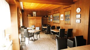 A restaurant with wooden walls and hexagonal tile flooring. Tables and chairs are arranged for dining. - Holiday Home Fabryshof in Bollendorf (Bollendorf)