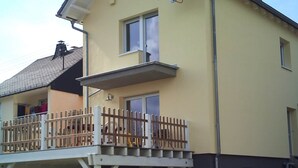 A two-story house with a balcony and a covered porch. - Stay With Garden in the Hunsruck (Stipshausen)