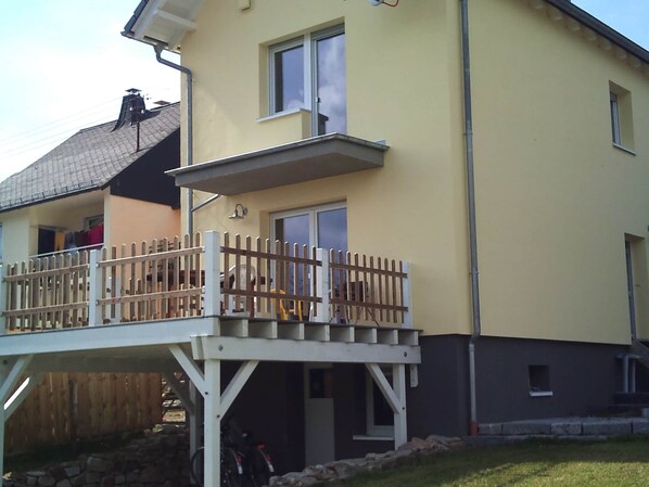 Une maison à deux étages dotée d’un balcon et d’un porche abrité.