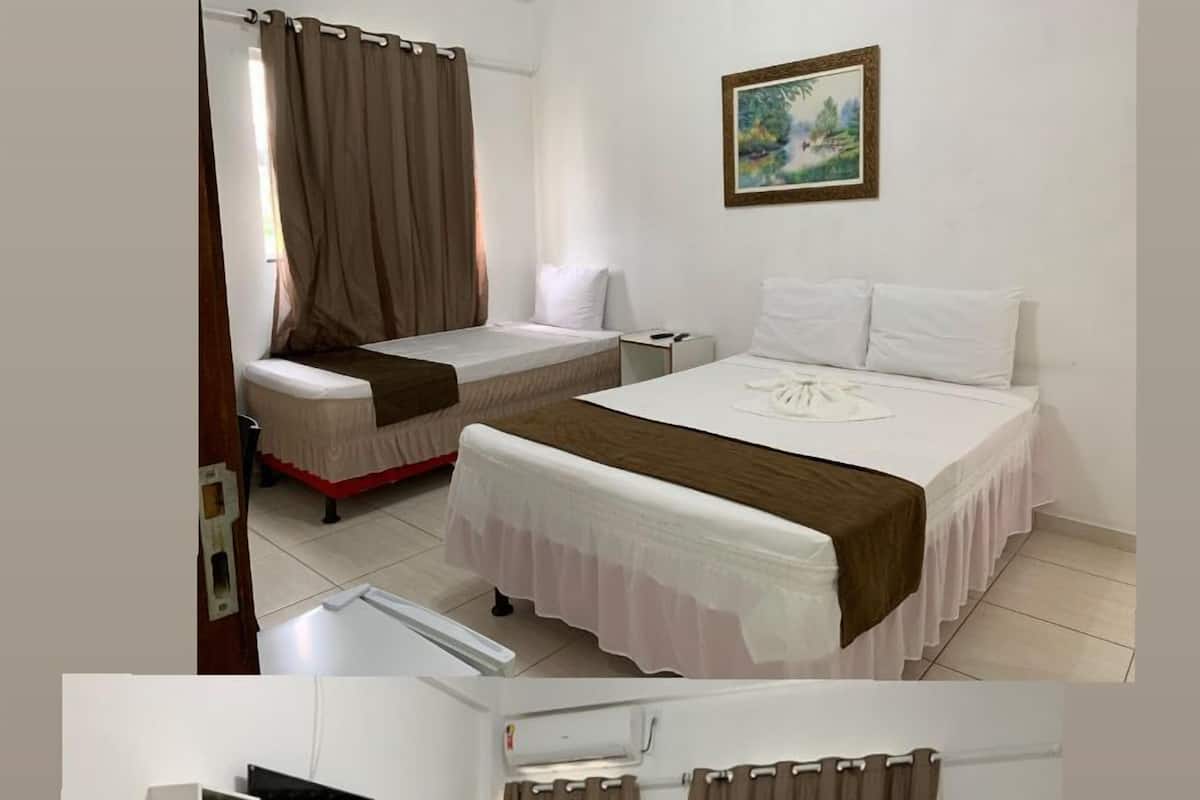 Habitación de hotel con cama, escritorio, silla, televisor y puerta con un cartel.