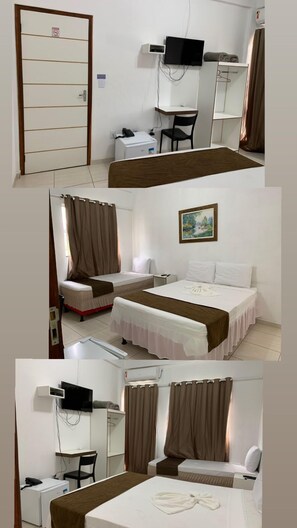 A hotel room with a bed, a desk, a chair, a TV, and a door with a sign. - Hotel Alelos (Ituaçu)