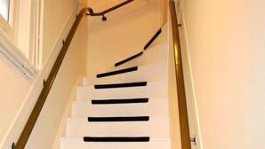 A staircase with black handrails and white steps. - Zaras Studio Apollo (Zandvoort)