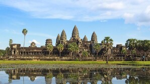 Un vaste complexe de temples comprenant de nombreuses tours et dont l’image se reflète dans l’eau.
