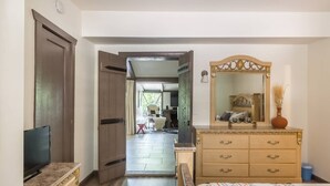 A bedroom with a bed, dresser, TV, and a view into the living area. - LAZY C RANCH - POOL, ANIMALS, DESERT RANCH EXPERIENCE (Palm Springs)