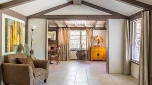 A spacious living room with a high ceiling, a sofa, a coffee table, a statue, and a yellow cabinet. - LAZY C RANCH - POOL, ANIMALS, DESERT RANCH EXPERIENCE (Palm Springs)