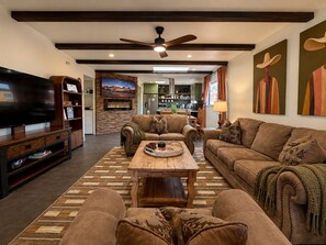 A living room with a television, sofa, coffee table, and a fireplace.