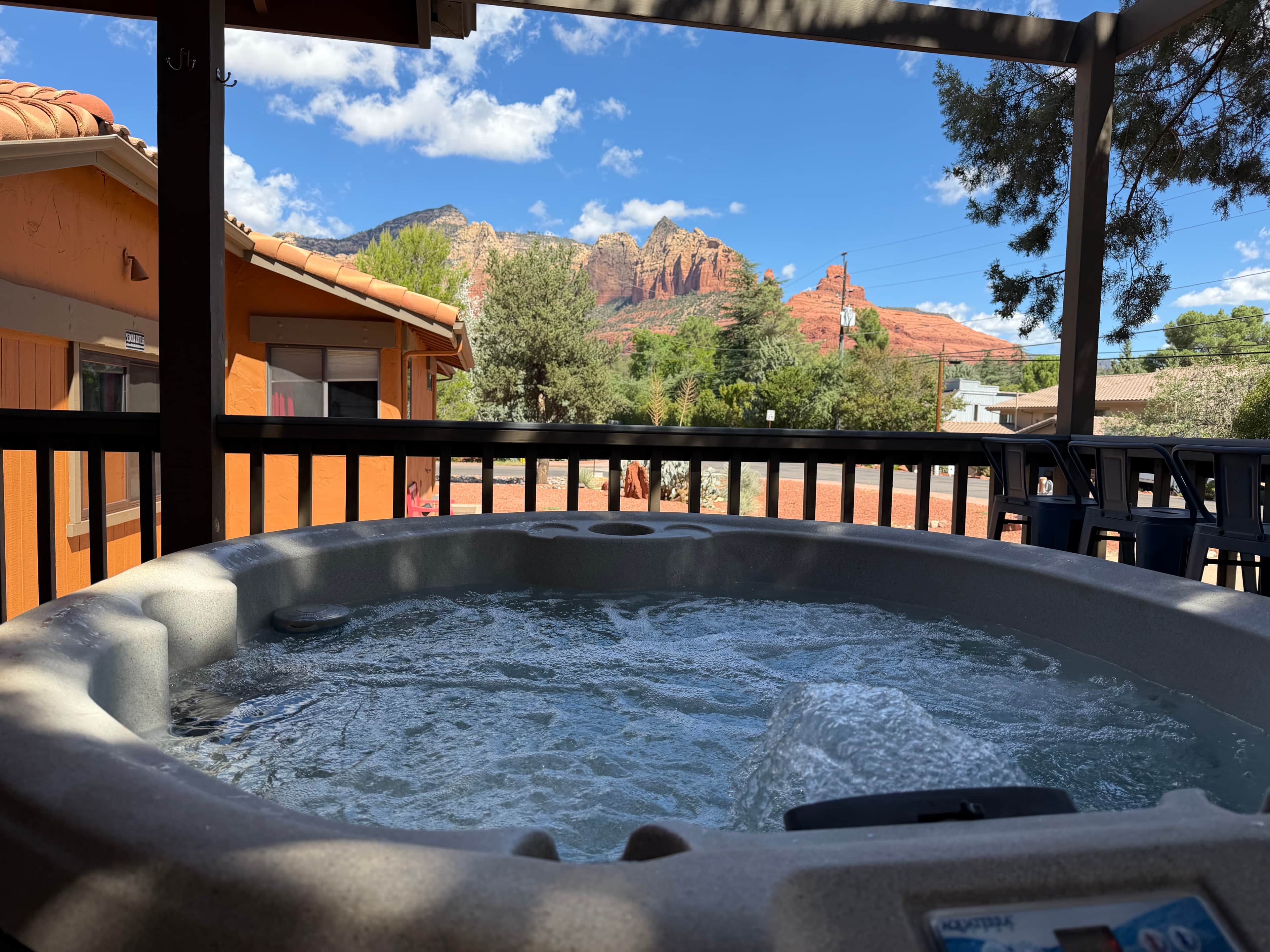 A hot tub with a view of red rock formations and a clear sky.