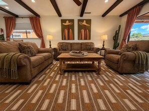 A living room with two sofas, a coffee table, and two wall-mounted lamps.