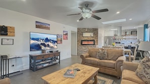 Una sala de estar moderna con chimenea, televisor y comedor.