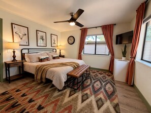 A bedroom with a bed, bedside tables, a bench, a ceiling fan, a clock, and a window with curtains. - Uptown House+Walkable+Full Kitchen+SelfCkin+PetsOK+Hot Tub, The Uptown House~Red Rock Getaway (Sedona)